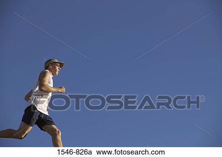 Low angle view of a man running View Large Photo Image Stock Image - Low angle view of a man running. Fotosearch