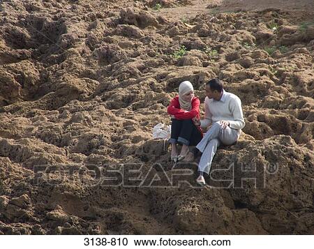Mid adult couple sitting on rugged rocks, Tipaza, Algeria View Large Photo Image Stock Image - Mid adult couple sitting on rugged rocks, Tipaza, Algeria. Fotosearch