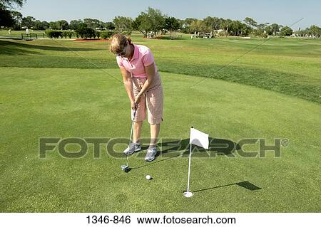 Mid adult woman playing golf View Large Photo Image Stock Photograph - Mid adult woman playing golf. Fotosearch