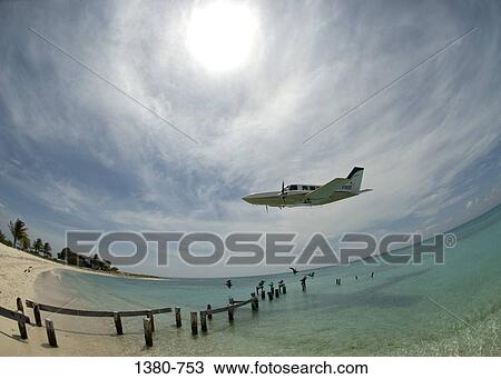 Stock Image - Private airplane in flight over the sea, Los Roques, Venezuela. Fotosearch