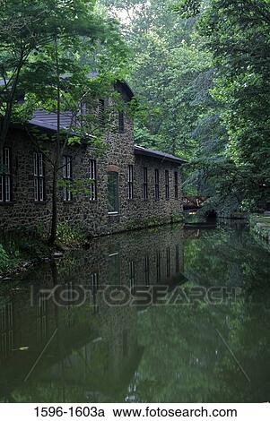 Stock Image - Reflection of an industrial building in water, Hagley Museum and Library, Wilmington, Delaware, USA. Fotosearch