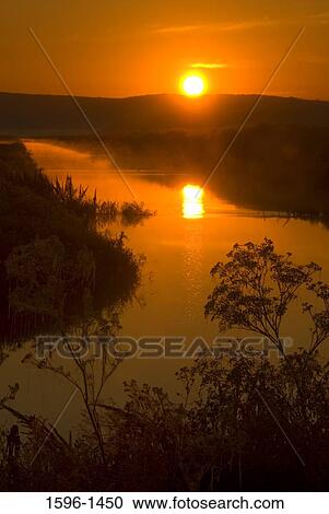 Reflection of the sun in water at sunrise, Lower Klamath National Wildlife Refuge, Klamath Basin, California, USA View Large Photo Image Stock Image - Reflection of the sun in water at sunrise, Lower Klamath National Wildlife Refuge, Klamath Basin, California, USA. Fotosearch
