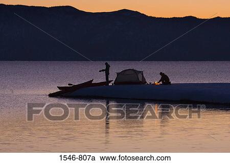 Stock Image - Silhouette of a man and a woman camping at the lakeside, Lake Tahoe, California, USA. Fotosearch