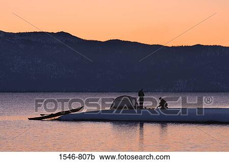Stock Image - Silhouette of a man and a woman camping at the lakeside, Lake Tahoe, California, USA. Fotosearch