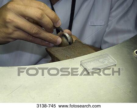 Stern jeweller working on a ring in workshop View Large Photo Image Stock Photography - Stern jeweller working on a ring in workshop. Fotosearch