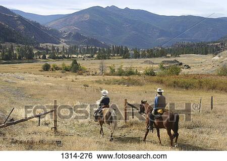 Two cowboys riding horses, Montana, USA View Large Photo Image Stock Photograph - Two cowboys riding horses, Montana, USA. Fotosearch