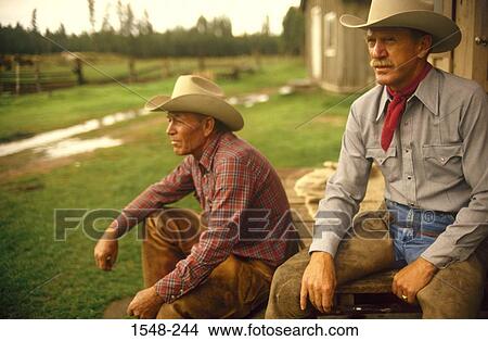 Two cowboys sitting by a barn View Large Photo Image Picture - Two cowboys sitting by a barn. Fotosearch