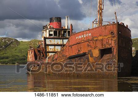 Stock Image - Abandoned ship in the sea, Letterfrack Pier, Letterfrack, Connemara, County Galway, Connacht Province, Republic of Ireland. Fotosearch