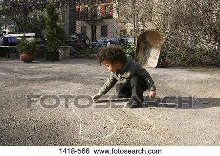 Boy drawing with chalk on a road View Large Photo Image Stock Photograph - Boy drawing with chalk on a road. Fotosearch