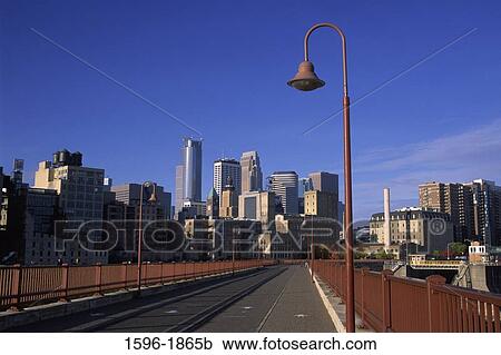 Stock Image - Buildings in a city viewed from a bridge, Stone Arch Bridge, Minneapolis, Hennepin County, Minnesota, USA. Fotosearch
