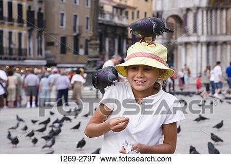 Close-up of a girl feeding pigeons, St. Mark's Square, Venice, Veneto, Italy View Large Photo Image Stock Photo - Close-up of a girl feeding pigeons, St. Mark's Square, Venice, Veneto, Italy. Fotosearch
