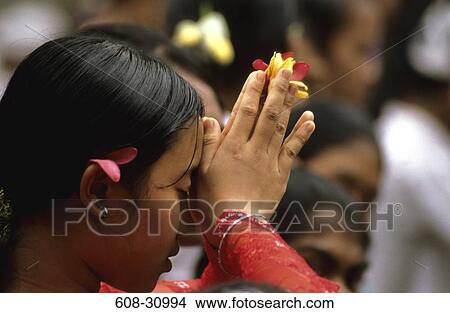 Close-up of a young woman praying in a temple, Ubud, Bali, Indonesia View Large Photo Image Picture - Close-up of a young woman praying in a temple, Ubud, Bali, Indonesia. Fotosearch
