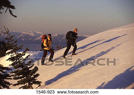 Couple climbing a snow covered mountain, Lake Tahoe, California, USA View Large Photo Image Stock Image - Couple climbing a snow covered mountain, Lake Tahoe, California, USA. Fotosearch