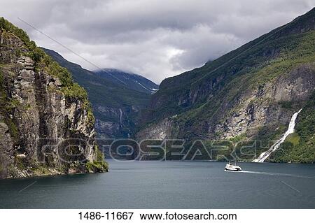 Ferry in the fjord with mountains in the background, Geirangerfjord, More og Romsdal, Sunnmore, Norway View Large Photo Image Stock Photo - Ferry in the fjord with mountains in the background, Geirangerfjord, More og Romsdal, Sunnmore, Norway. Fotosearch