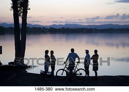 Five people standing at the lakeside View Large Photo Image Stock Image - Five people standing at the lakeside. Fotosearch