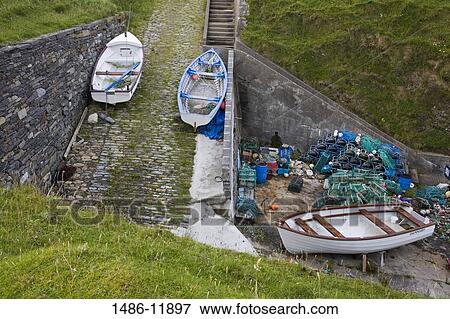 Stock Photo - Garbage cans with fishing boats on a pier, Malin Beg, County Donegal, Ulster Province, Ireland. Fotosearch