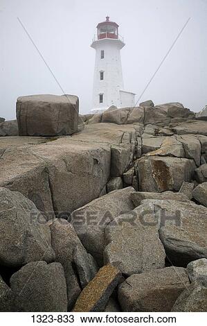 Stock Image - Lighthouse on a cliff, Peggy's Cove Lighthouse, Peggy's Cove, Nova Scotia, Canada. Fotosearch