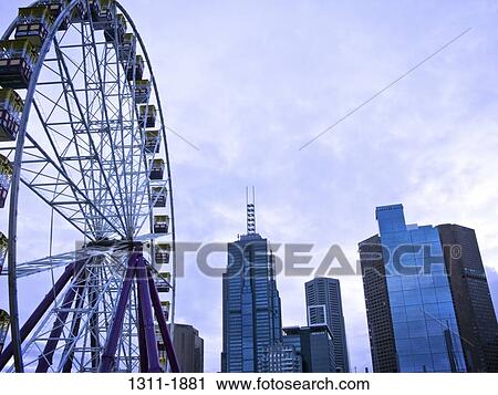 Low angle view of a ferris wheel with skyscrapers in the background, Melbourne Park, Melbourne, Victoria, Australia View Large Photo Image Stock Image - Low angle view of a ferris wheel with skyscrapers in the background, Melbourne Park, Melbourne, Victoria, Australia. Fotosearch