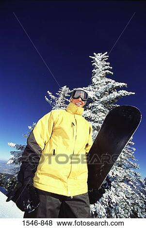 Low angle view of a man holding a snowboard, Diamond Peak, Nevada, USA View Large Photo Image Stock Photo - Low angle view of a man holding a snowboard, Diamond Peak, Nevada, USA. Fotosearch