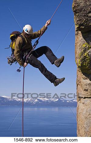 Man rappelling off a cliff, Lake Tahoe, Nevada, USA View Large Photo Image Stock Image - Man rappelling off a cliff, Lake Tahoe, Nevada, USA. Fotosearch