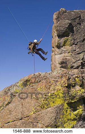 Stock Photo - Man rappelling off a cliff, Lake Tahoe, Nevada, USA. Fotosearch