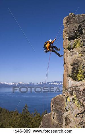 Man rappelling off a cliff, Lake Tahoe, Nevada, USA View Large Photo Image Stock Photo - Man rappelling off a cliff, Lake Tahoe, Nevada, USA. Fotosearch