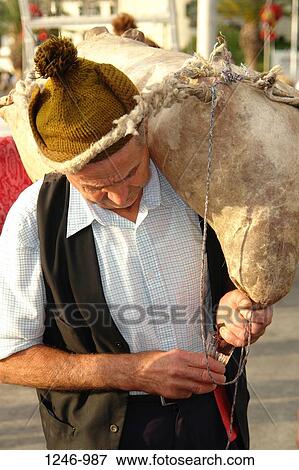 Member from a Porto da Cruz folklore group pouring wine from an old wineskin, Funchal, Madeira, Portugal View Large Photo Image Stock Photo - Member from a Porto da Cruz folklore group pouring wine from an old wineskin, Funchal, Madeira, Portugal. Fotosearch