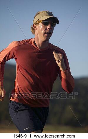 Mid adult man jogging View Large Photo Image Stock Image - Mid adult man jogging. Fotosearch