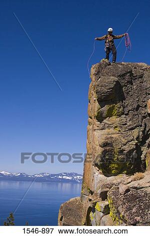 Mountaineer standing on top of a cliff and coiling his climbing rope, Lake Tahoe, Nevada, USA View Large Photo Image Stock Photo - Mountaineer standing on top of a cliff and coiling his climbing rope, Lake Tahoe, Nevada, USA. Fotosearch