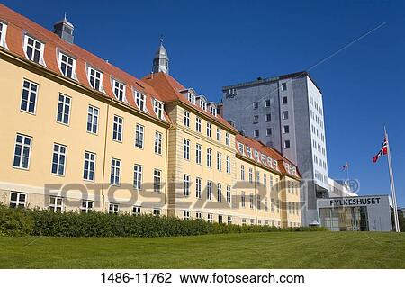 Stock Image - Norwegian flag fluttering in front of a county hall, Troms County Hall, Tromso, Toms County, Nord-Norge, Norway. Fotosearch