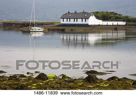 Stock Photo - Reflection of a building in water, Finavarra Peninsula, The Burren, County Clare, Munster Province, Republic of Ireland. Fotosearch