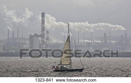 Sailboat in a bay with an oil refinery in the background, Bay Of Fundy, St. John, New Brunswick, Canada View Large Photo Image Stock Image - Sailboat in a bay with an oil refinery in the background, Bay Of Fundy, St. John, New Brunswick, Canada. Fotosearch
