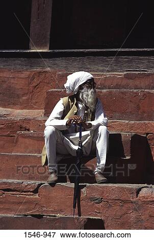 Stock Photo - Senior man sitting on steps, Kathmandu Durbar Square, Kathmandu, Nepal. Fotosearch