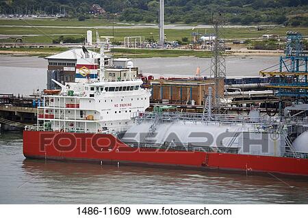 Stock Photo - Ship at a harbor, Fawley Oil Refinery, Southampton, Hampshire, England. Fotosearch