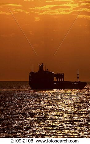 Stock Photo - Silhouette of a container ship at sunset, Strait Of Georgia, British Columbia, Canada. Fotosearch