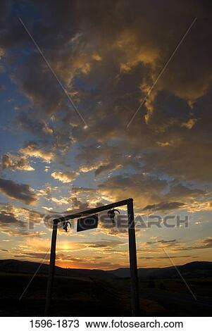 Stock Image - Silhouette of a ranch at sunrise, Powell County, Montana, USA. Fotosearch
