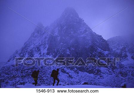 Stock Image - Silhouette of hikers walking in snow, Dusy Basin, Fresno, California, USA. Fotosearch