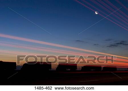 Stock Image - Silhouette of trucks at dusk, Interstate 80, Wyoming, USA. Fotosearch