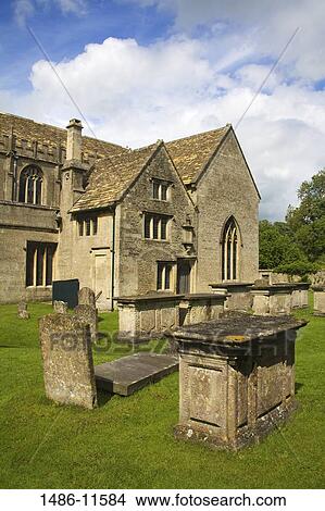 Picture - Tombstones in a cemetery in front of a church, St. Cyriac's Church, Lacock, Wiltshire, England. Fotosearch