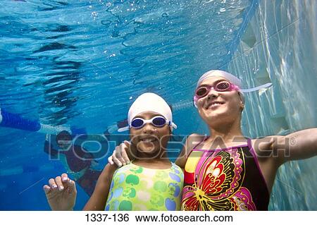 Two girls swimming in a swimming pool View Large Photo Image Stock Photograph - Two girls swimming in a swimming pool. Fotosearch