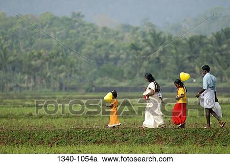 Two girls walking with their parents, Kerala, India View Large Photo Image Stock Image - Two girls walking with their parents, Kerala, India. Fotosearch