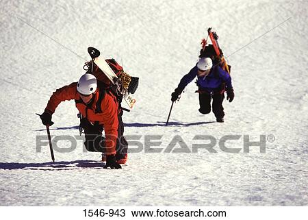 Stock Image - Two skiers climbing a snow covered mountain, Donner Peak, Placer County, California, USA. Fotosearch