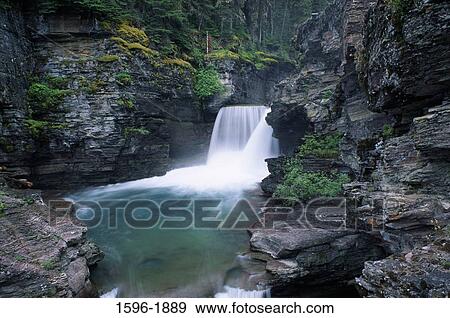 Stock Photo - Waterfall in a forest, St. Mary's Falls, US Glacier National Park, Montana, USA. Fotosearch
