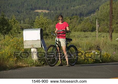 Woman reading a mail by a country mailbox while riding a bicycle, Parkdale, Hood River County, Oregon, USA View Large Photo Image Stock Image - Woman reading a mail by a country mailbox while riding a bicycle, Parkdale, Hood River County, Oregon, USA. Fotosearch