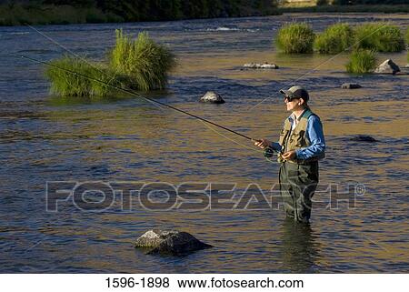 Young man fly-fishing in a river, Deschutes River State Recreation Area, Columbia River Gorge National Scenic Area, Oregon, USA View Large Photo Image Stock Photo - Young man fly-fishing in a river, Deschutes River State Recreation Area, Columbia River Gorge National Scenic Area, Oregon, USA. Fotosearch