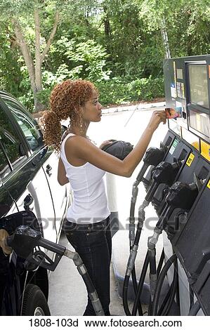 Stock Image - Young woman putting credit card into a credit card reader. Fotosearch