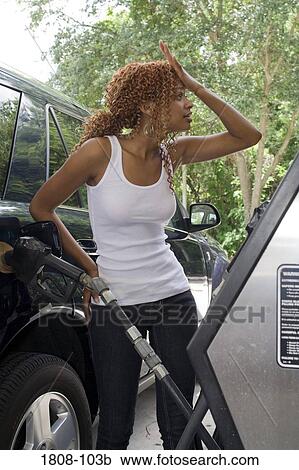 Young woman refueling a car View Large Photo Image Stock Image - Young woman refueling a car. Fotosearch