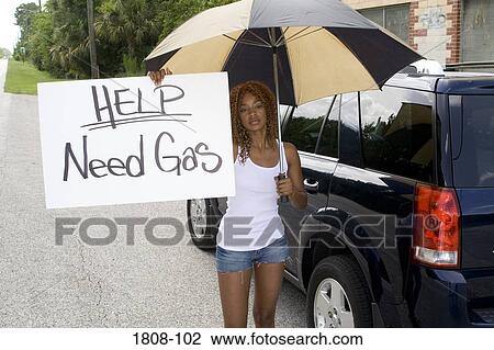 Young woman standing and holding a Help sign board View Large Photo Image Stock Image - Young woman standing and holding a Help sign board. Fotosearch