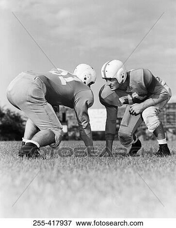 America football players crouching face to face View Large Photo Image Stock Photo - America football players crouching face to face. Fotosearch