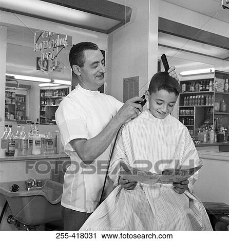 Stock Image - Barber shaving boy's head. Fotosearch